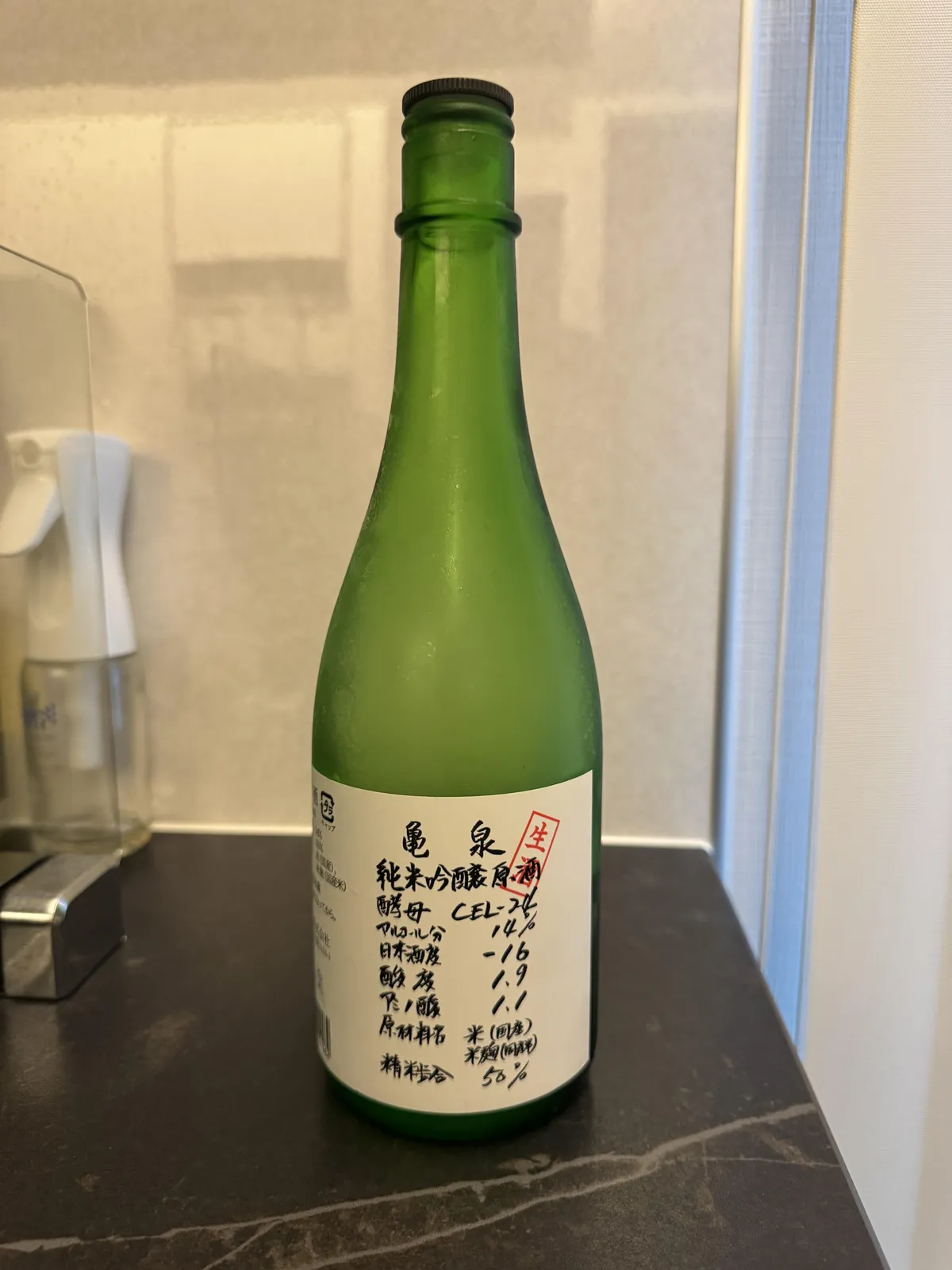 亀泉 純米吟醸原酒 CEL-24のボトル正面。緑色の瓶に手書き風のラベルが貼られている