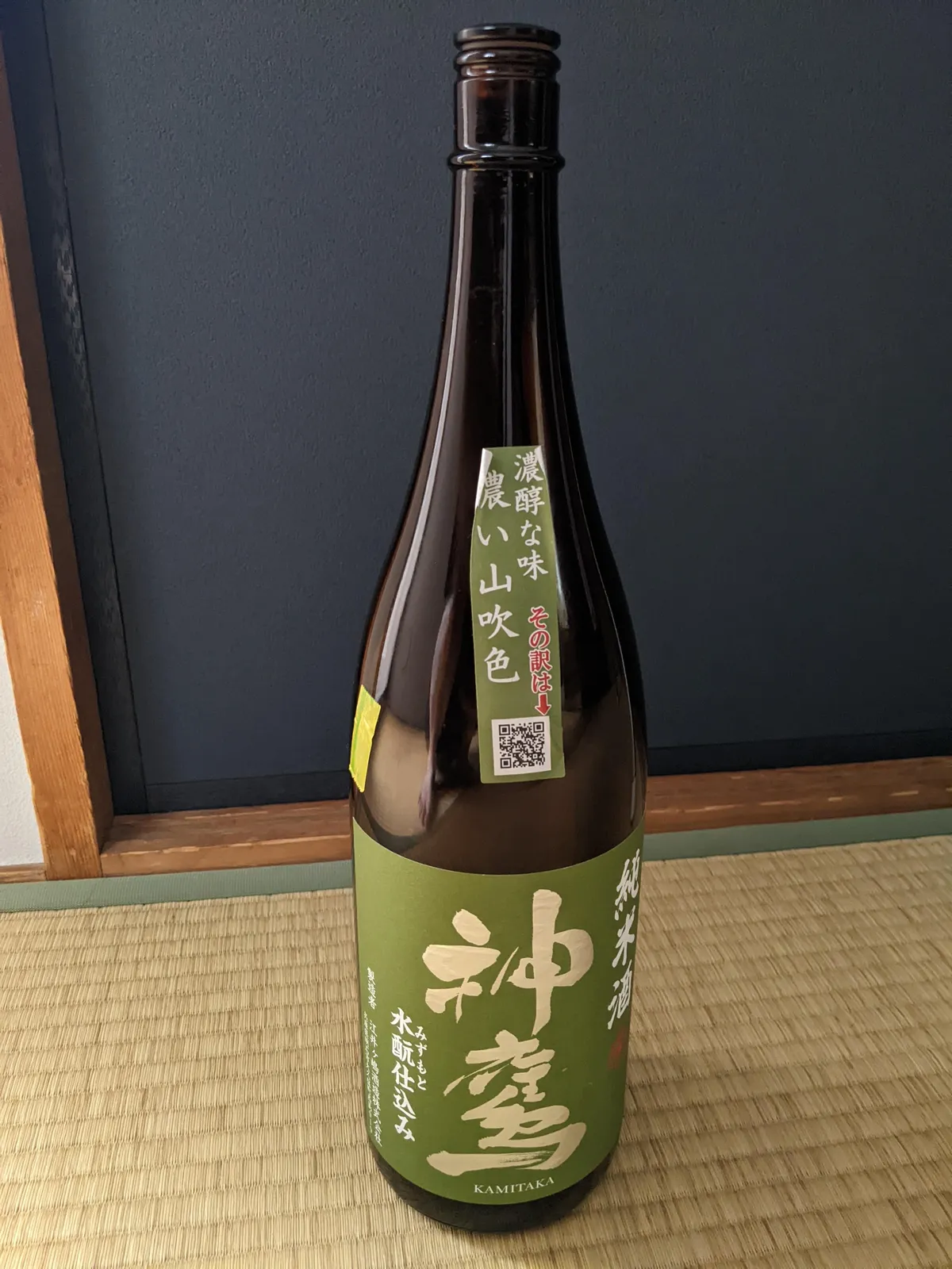 畳の上に置かれた神鷹純米酒 水酛仕込みの一升瓶