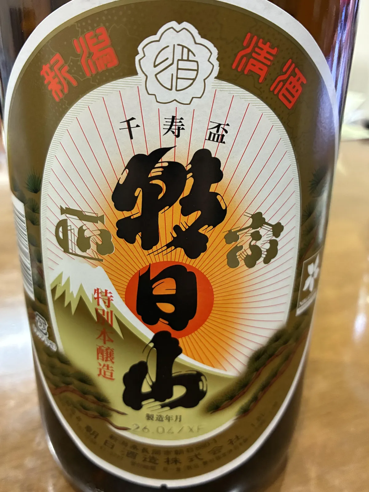 朝日山 益々繁盛のラベル。日の出と松が描かれたおめでたいデザインに力強い筆文字が躍る