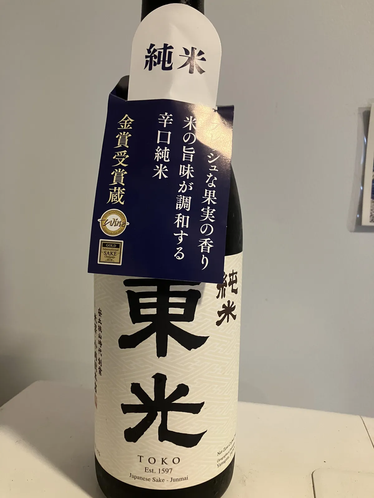東光 純米のボトル正面。大きな筆文字のロゴと、金賞受賞を知らせる首掛けが目を引きます