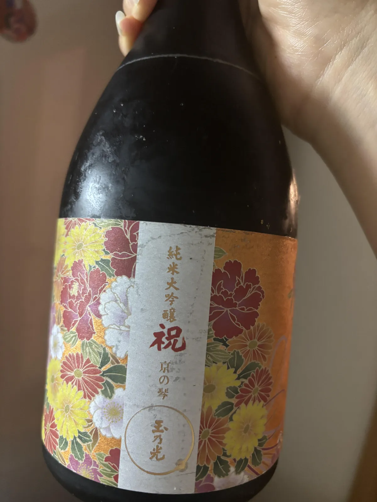 色鮮やかな花柄のラベルが貼られた玉乃光 純米大吟醸 祝100% 京の琴のボトル