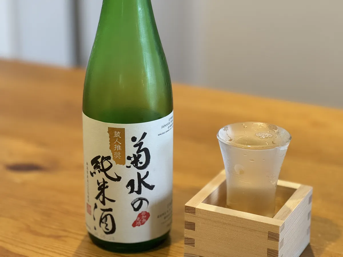 木目のテーブルに置かれた菊水の純米酒のボトルと、枡に入った冷えたグラス