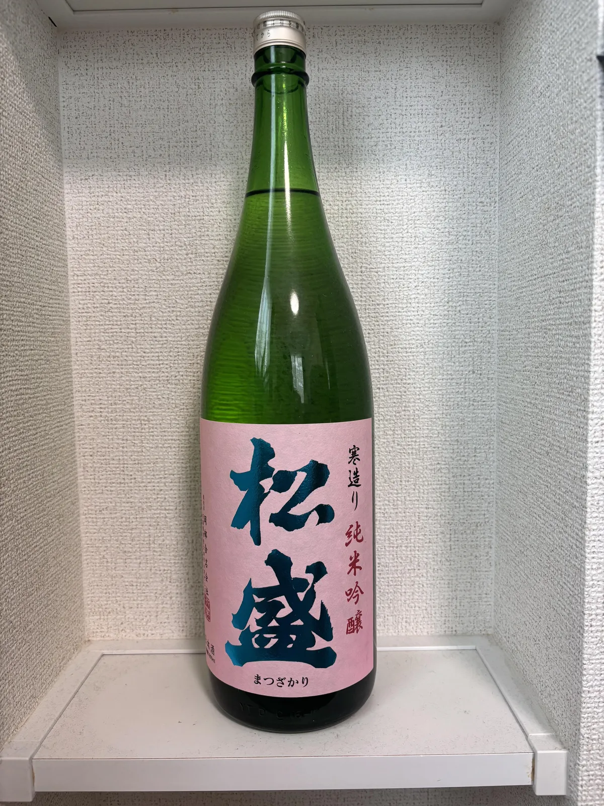 松盛 純米吟醸のボトル全体。ピンクのラベルに力強い筆致で銘柄名が書かれている