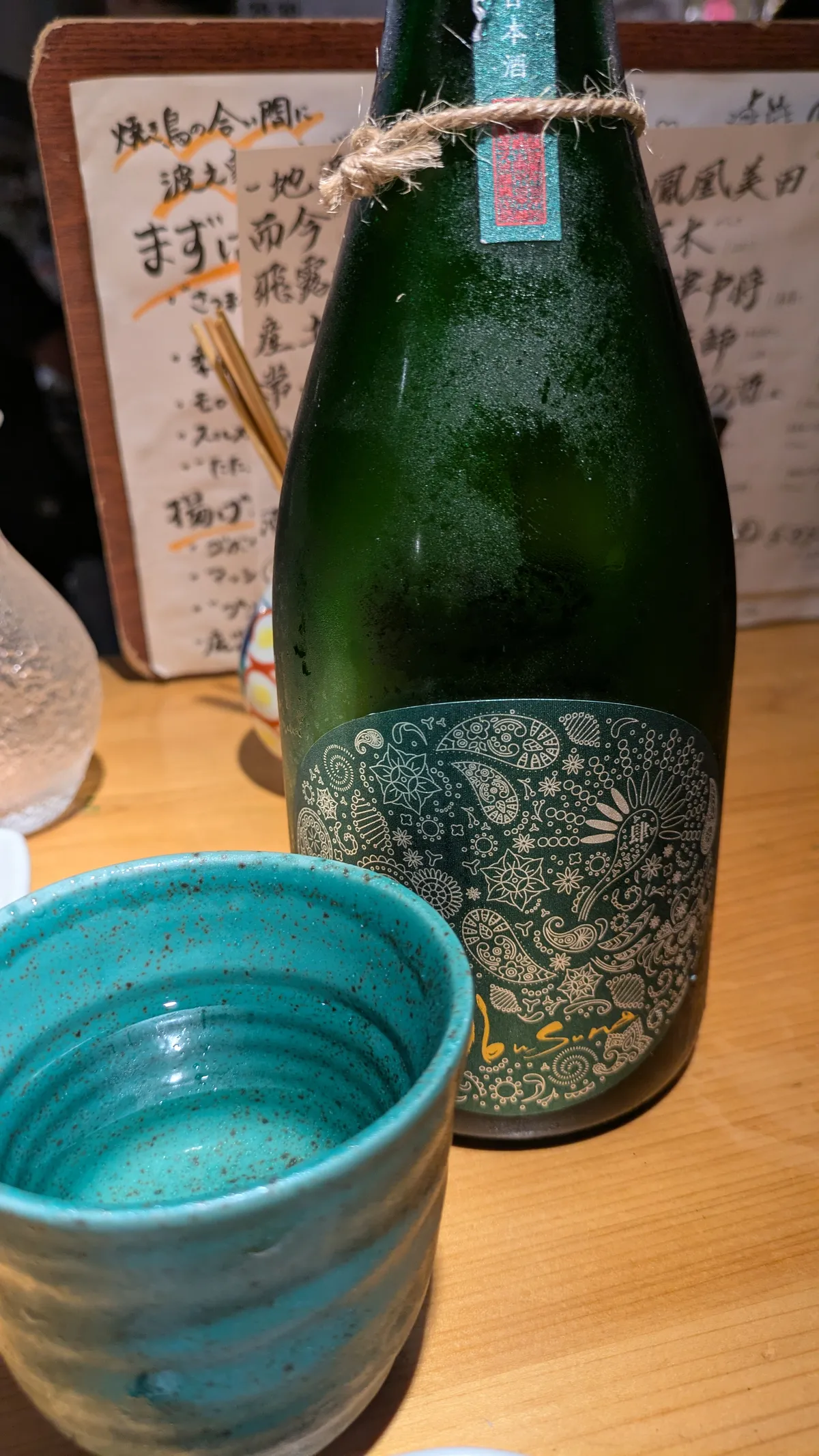 産土 穂増のボトルと、青いお猪口に注がれた日本酒