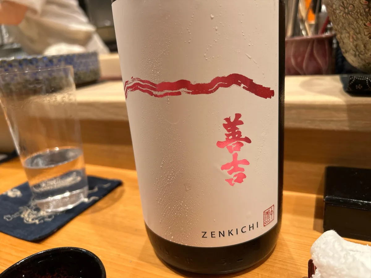 白地に赤い文字で善吉と書かれたラベルの日本酒ボトル