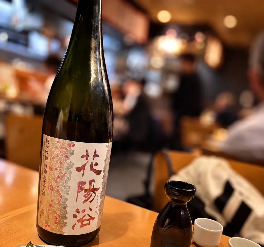 店内のテーブルに置かれた花陽浴のボトルと黒い徳利、お猪口