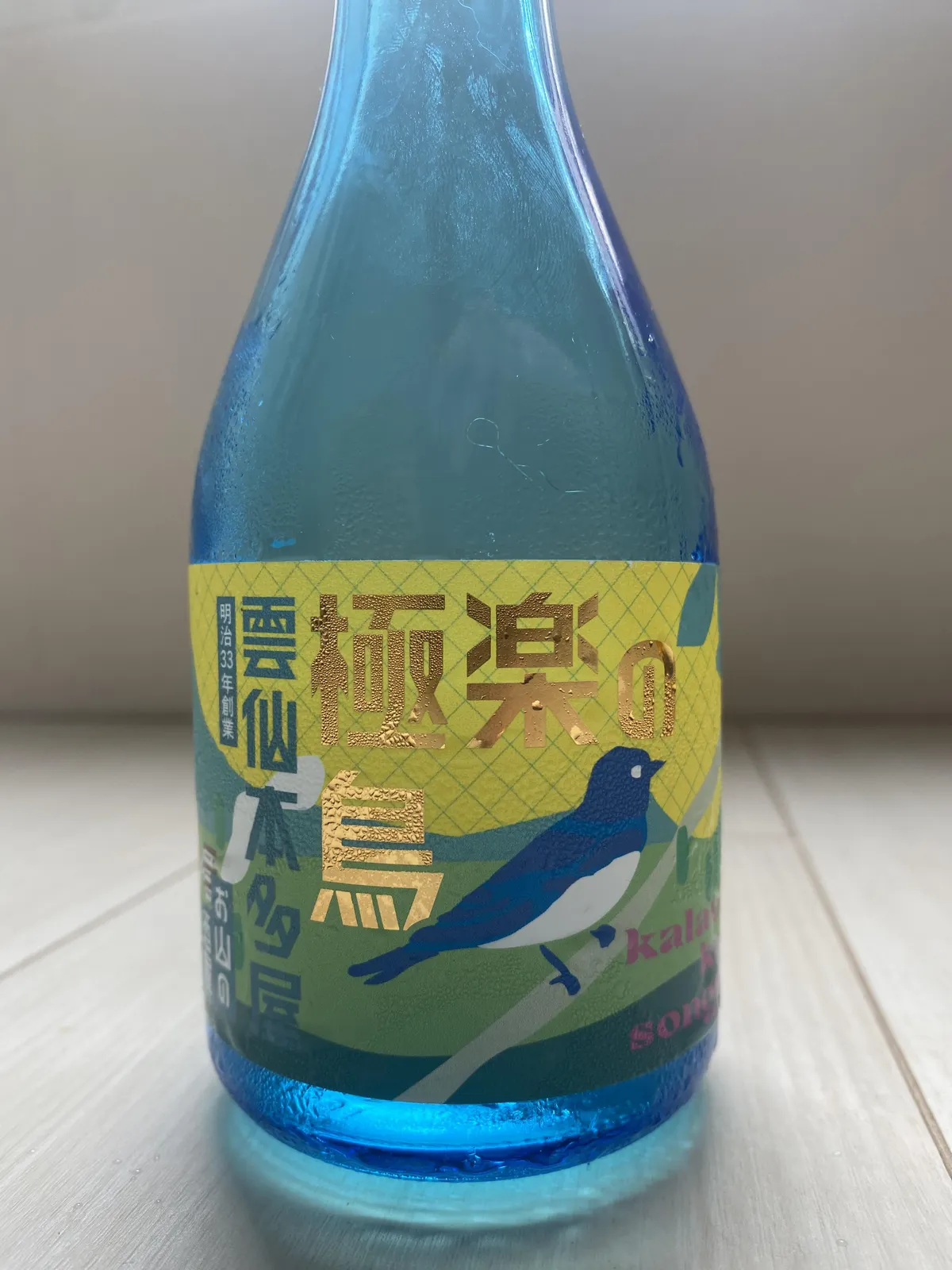 極楽の鳥のラベル。金色の文字と青い鳥のイラストが描かれている