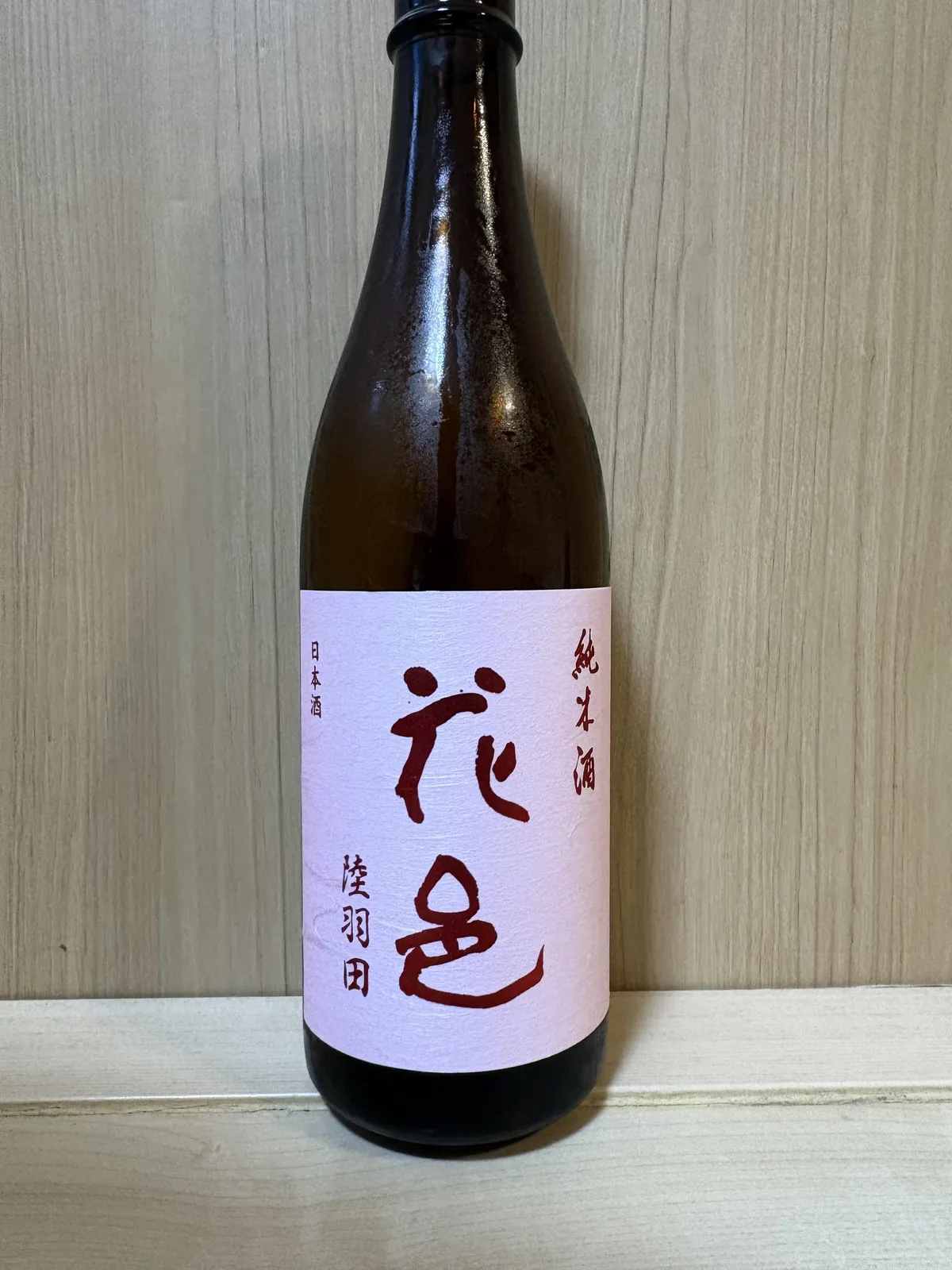 花邑 純米酒 陸羽田の淡いピンク色のラベルを正面から捉えた写真
