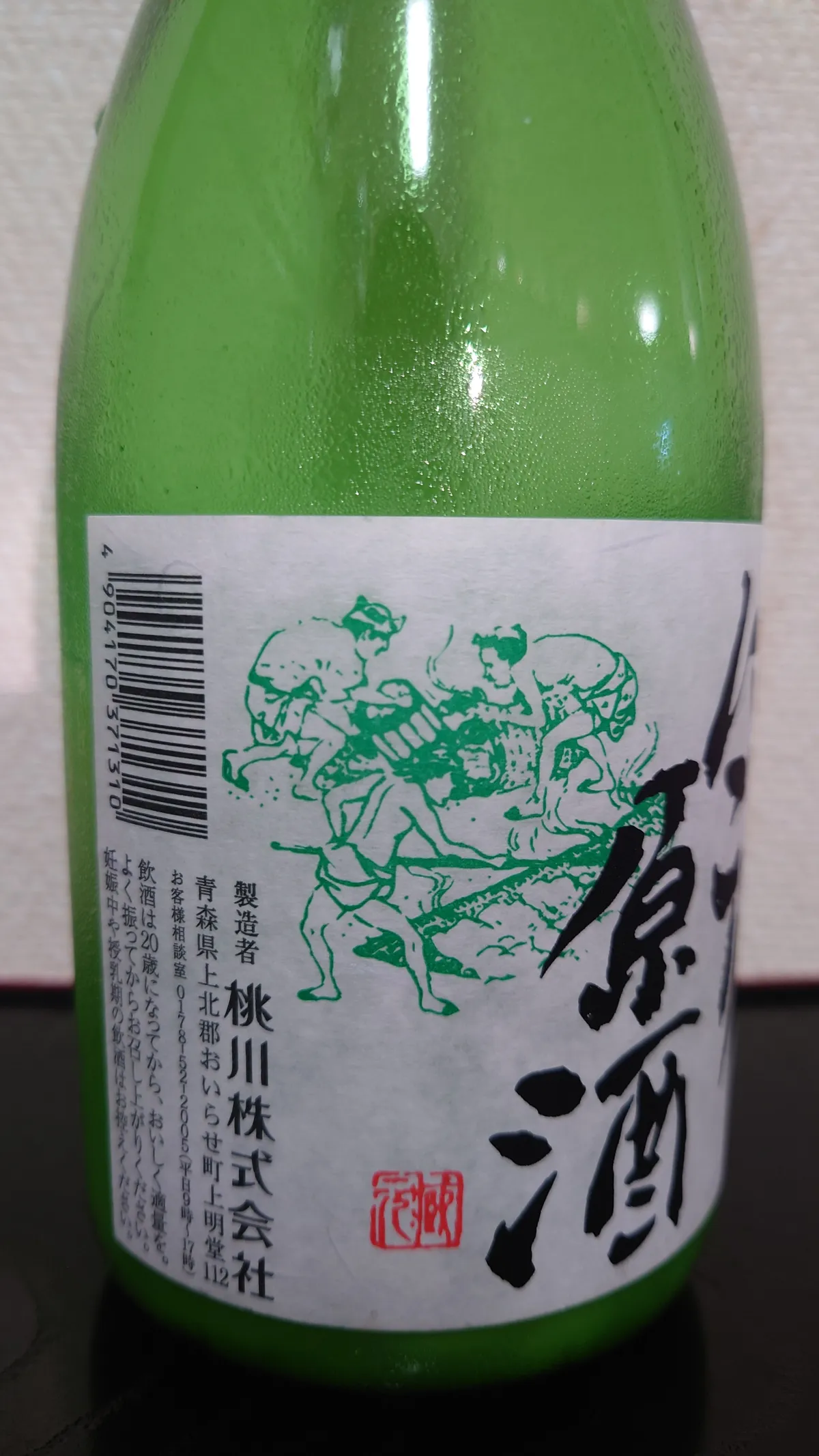 桃川 にごり原酒の側面ラベル。製造者の桃川株式会社の情報が記載されている