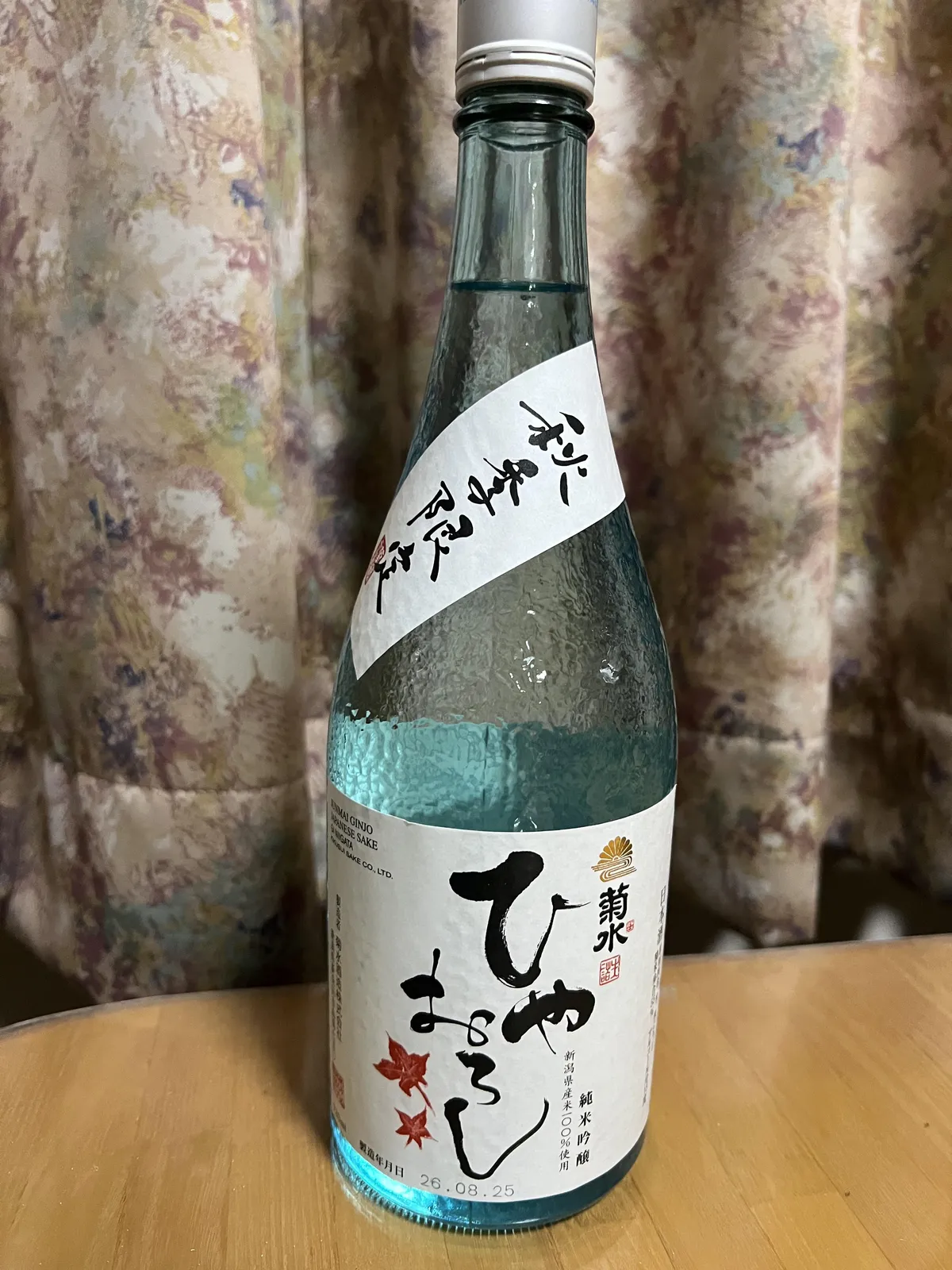 菊水 純米吟醸 ひやおろしのボトル全体。涼しげな水色の瓶に紅葉が描かれたラベルが映える