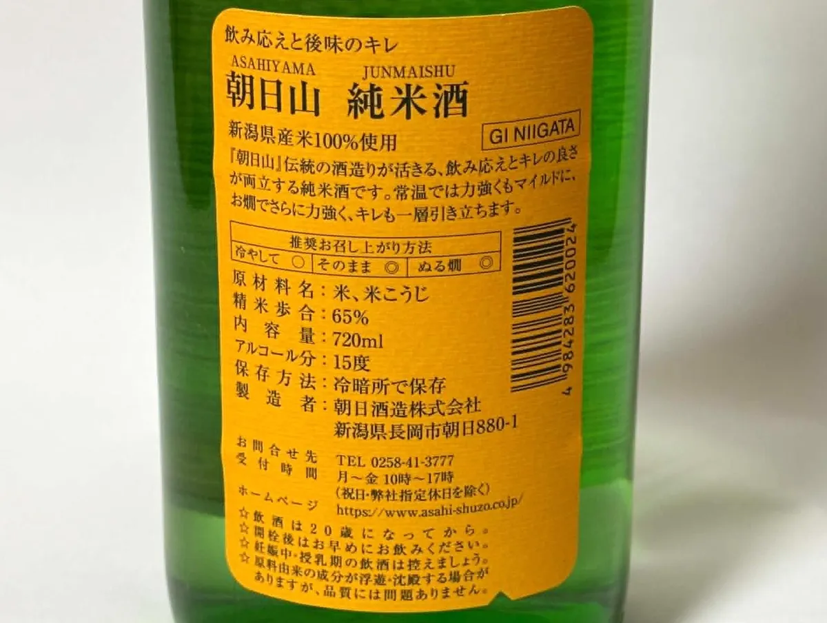 朝日山 純米酒の裏ラベル。オレンジ色の背景に、飲み方や味わいの説明が記載されている