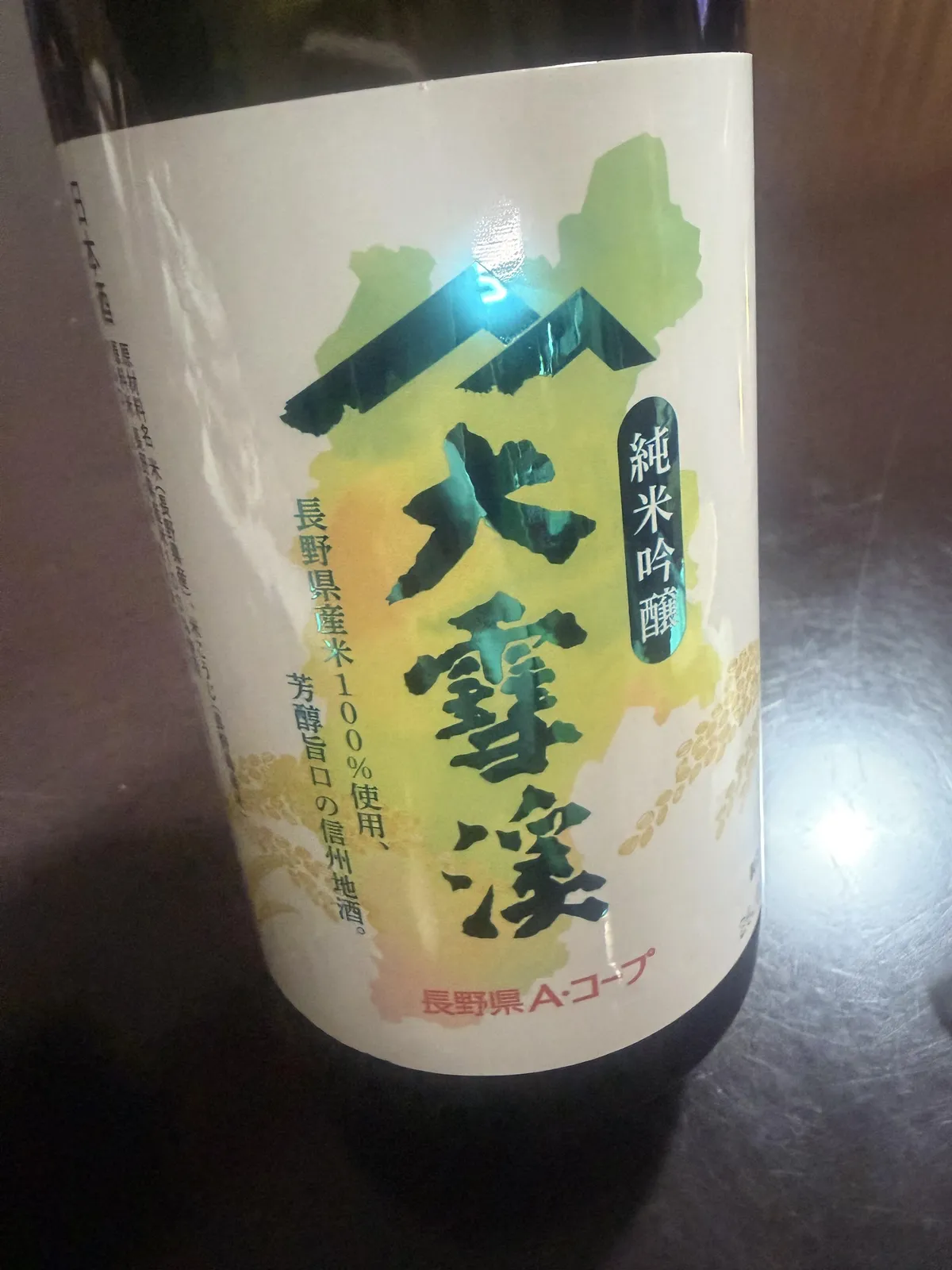 大雪渓 純米吟醸のボトル正面。長野県のシルエットと山並みが描かれたラベル