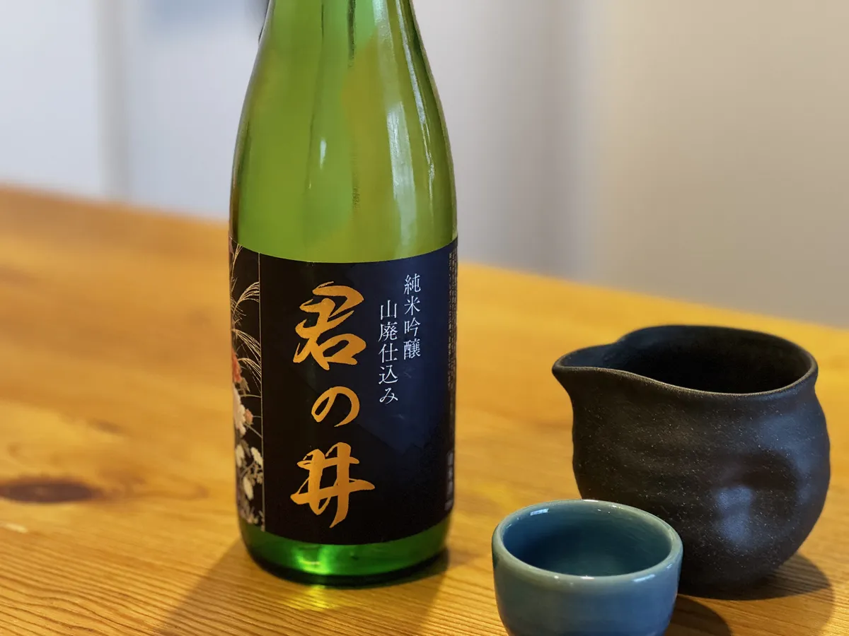 テーブルに置かれた君の井のボトルと、黒い片口、青いお猪口