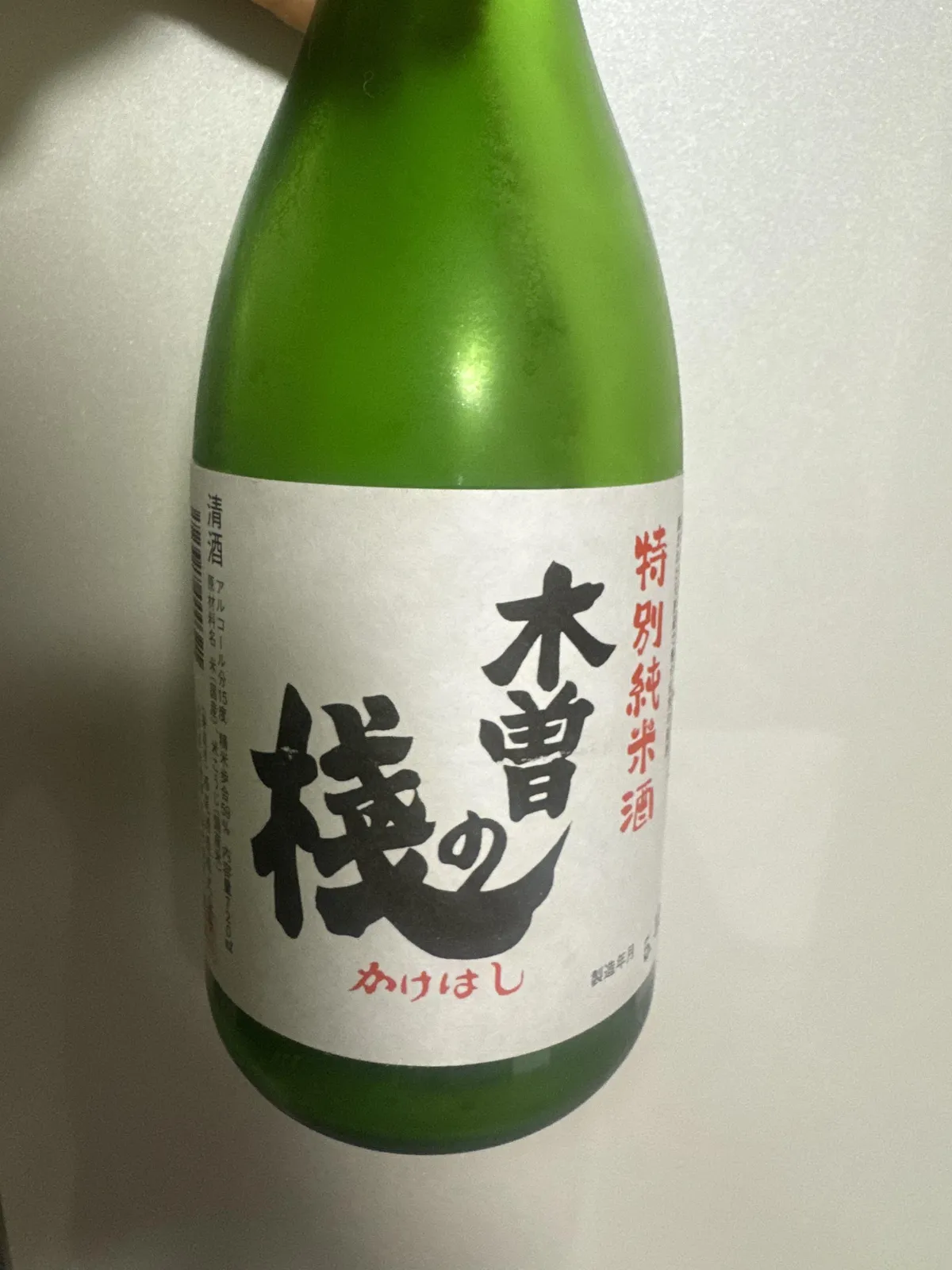 西尾酒造の木曽の桟 特別純米酒。緑色の瓶に白地のラベル、力強い黒文字の銘柄名が印象的