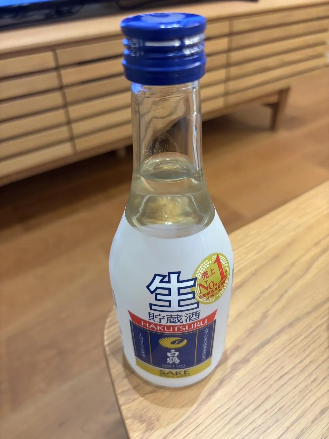 木目調のテーブルに置かれた上撰 白鶴 生貯蔵酒のボトル