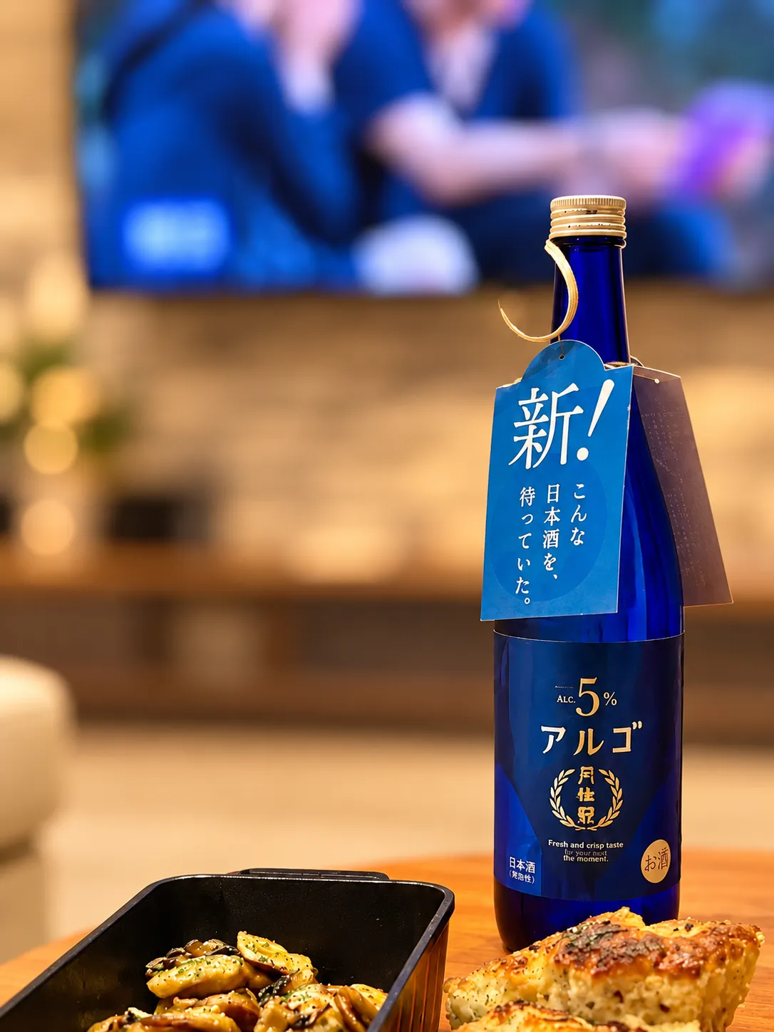 月桂冠 アルゴ 日本酒5.0の青いボトルとタグ、手前に並ぶ料理