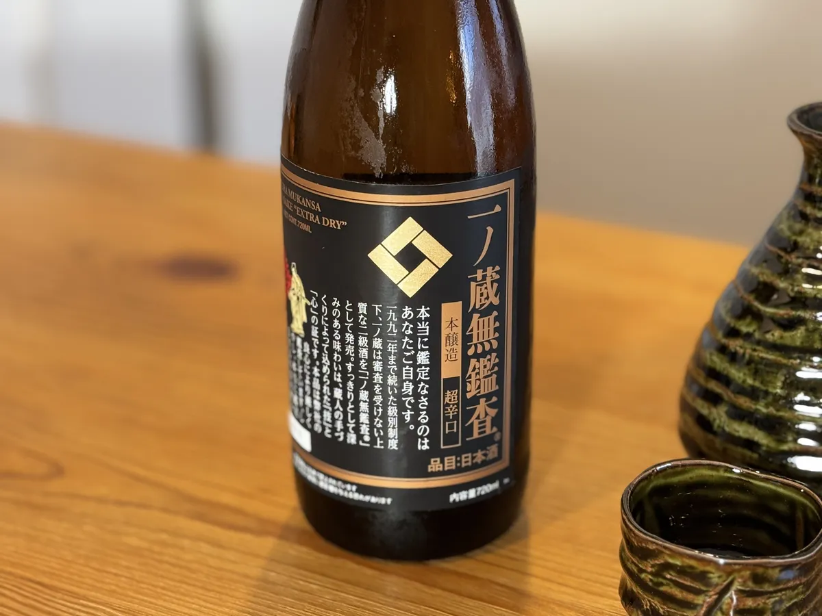 落ち着いた色合いの酒器と並ぶ一ノ蔵無鑑査のボトル